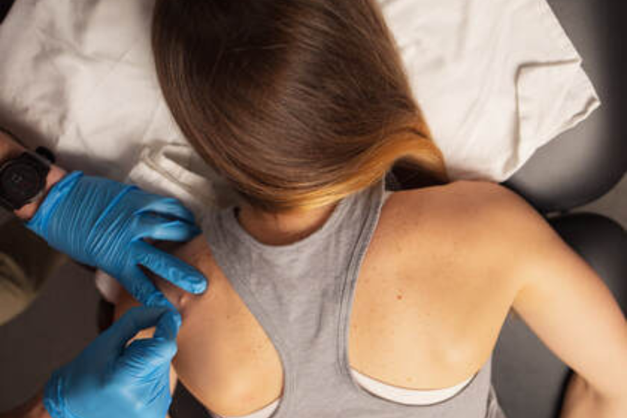 a woman in a gray tank top and blue gloves.