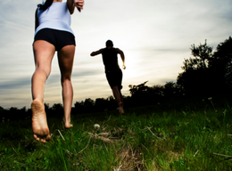 a couple of people that are running in the grass.