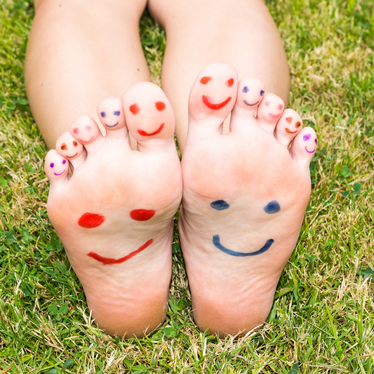 a person's feet with painted faces on them.