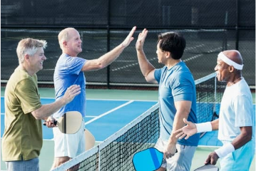 a group of men standing on top of a tennis court holding racquets.