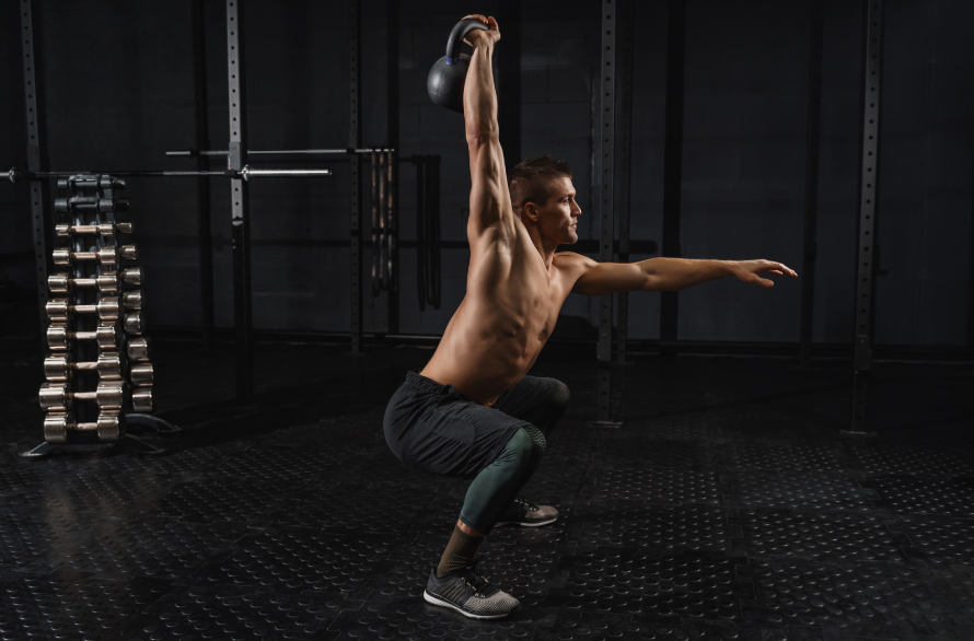 a shirtless man doing a squat exercise in a gym.