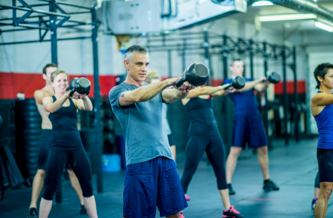 a group of people in a gym doing exercises.