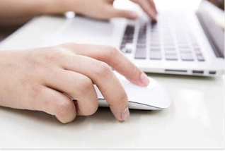 a person using a laptop computer on a desk.