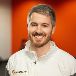 a man in a white jacket smiling for a picture.