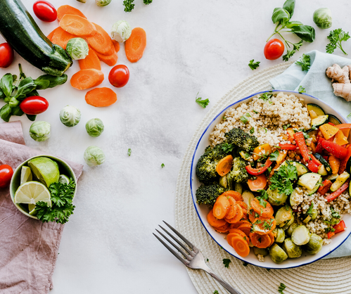 a plate of vegetables and rice on a table.