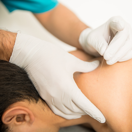 a man getting a procedure on the back of another man.