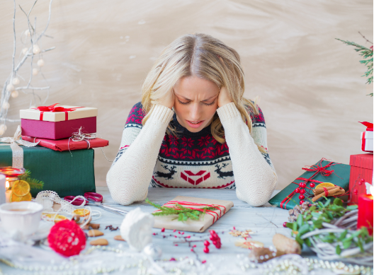 a woman sitting at a table covered in presents.