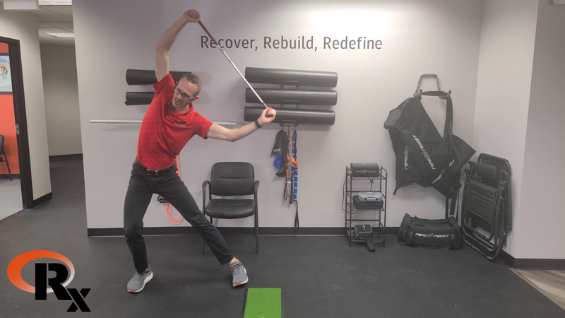 a man swinging a golf club in a room.