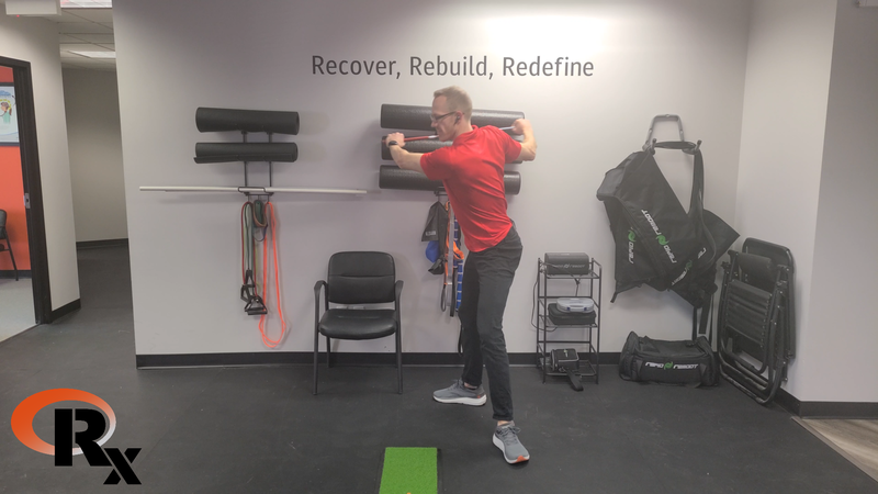 a man in a red shirt is doing exercises in a gym.