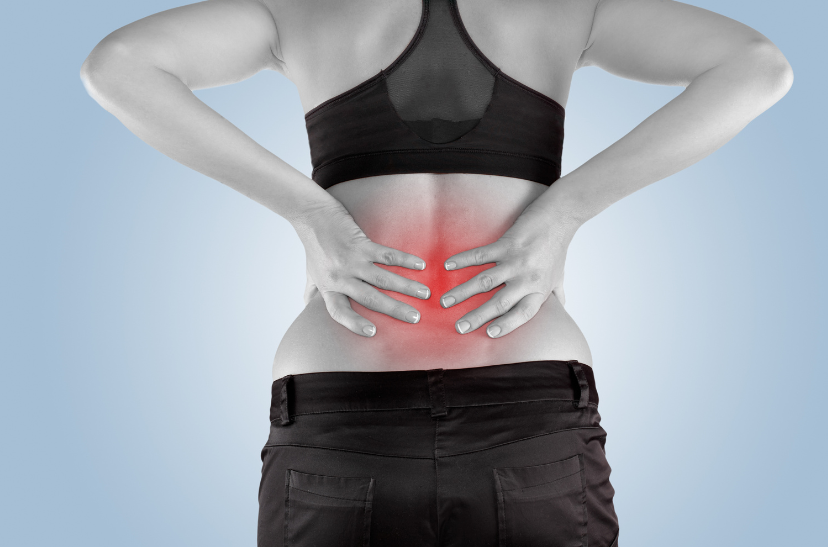 A woman with a back pain holding her back.