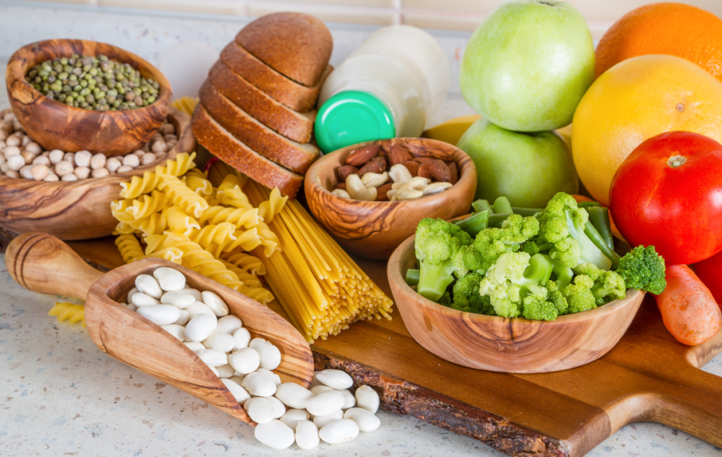 A wooden cutting board with a variety of fruits and vegetables.